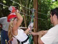 Guide and test pilot hooking up safety equipment before zipping